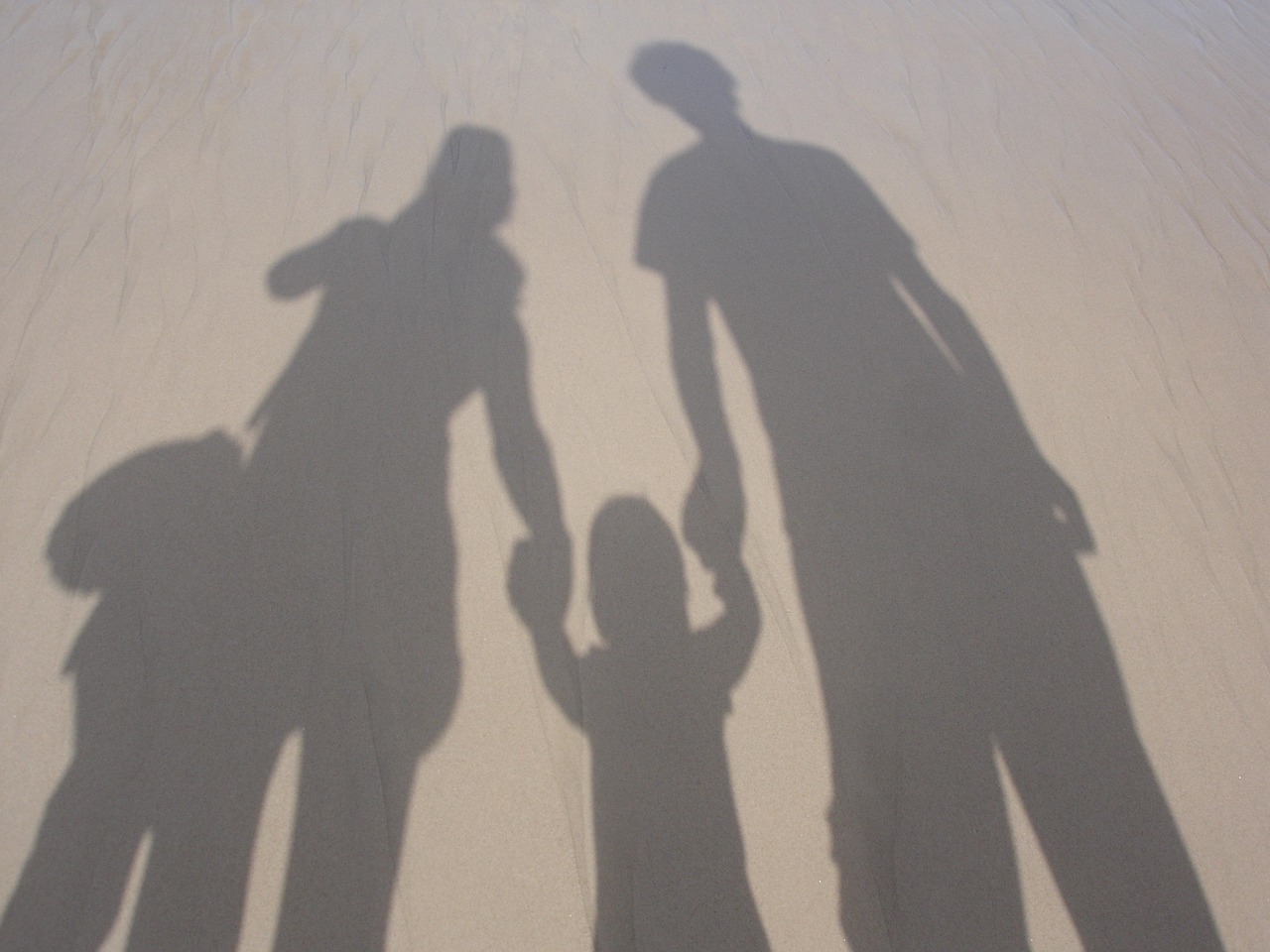 Silhouette of Parents Holding Hands with Their Child