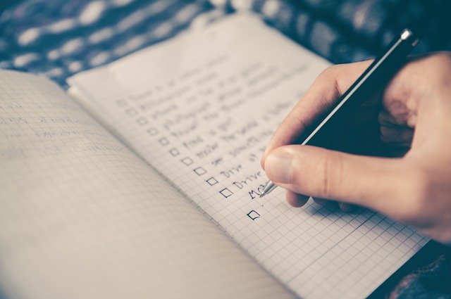 Hand Writing Checklist in Notebook