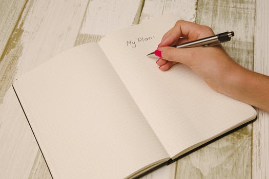 Hand Writing in an Open Journal with Pen