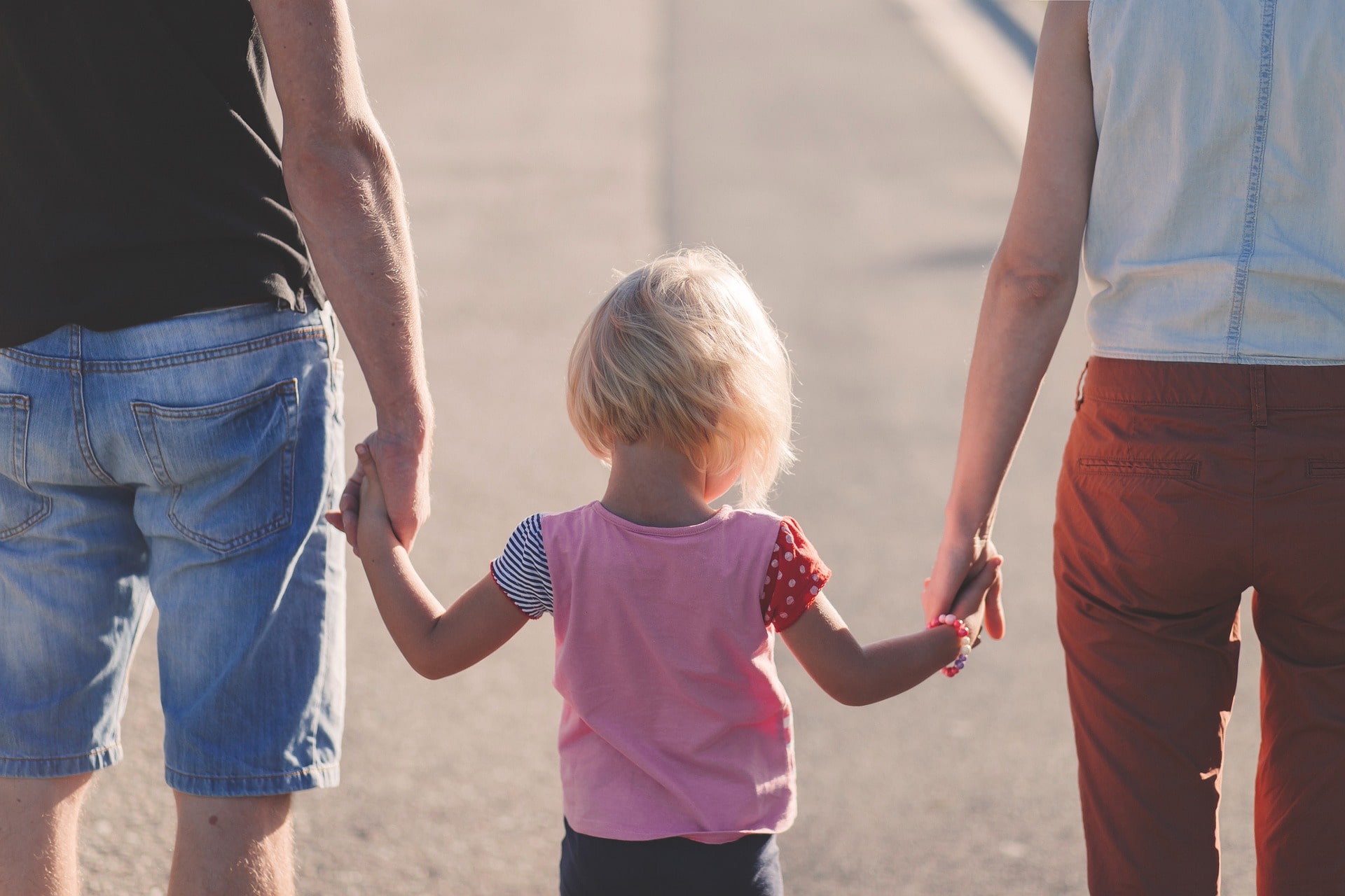 Mother and Father holding hands with Daughter